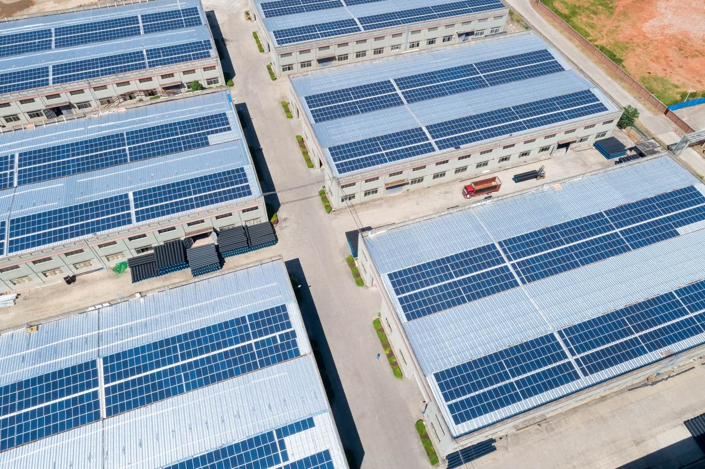 Aerial view of an industrial estate with rooftop solar PV arrays across multiple buildings